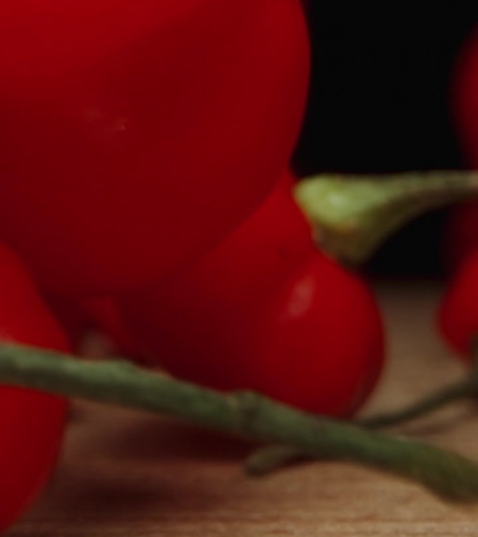垂直视频。“火鸡之星”品种的微红辣椒落在桌子上。缓慢的运动。宏多莉