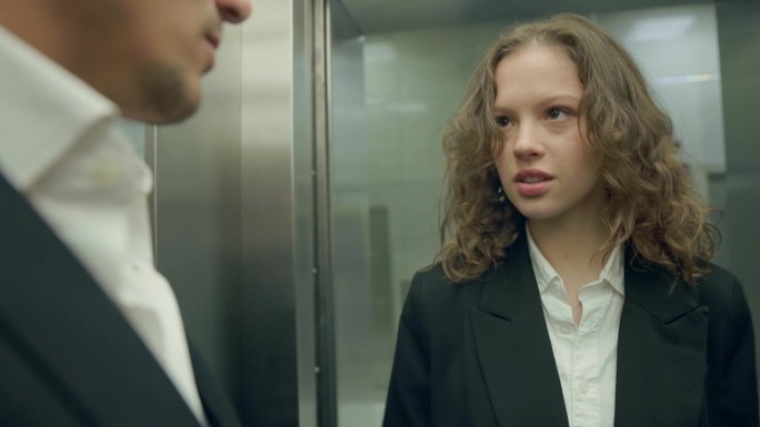 穿着职业装的女孩走进电梯。