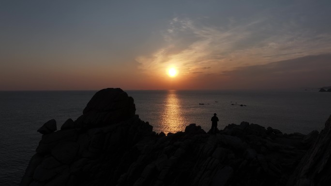 航拍威海市环翠区猫头山海岛礁石日出看海人