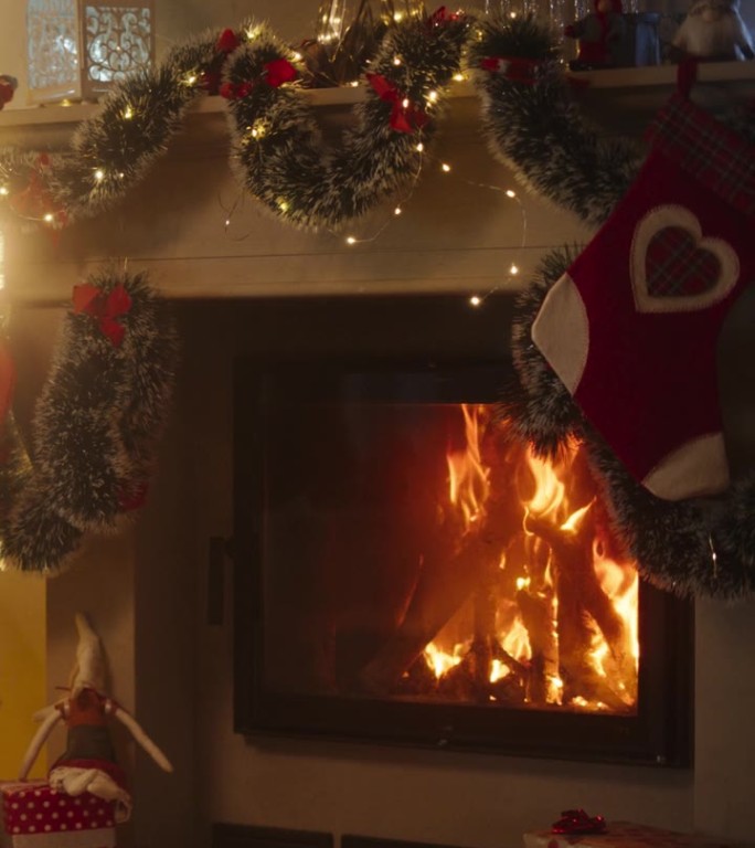 垂直屏幕:和平的雪圣诞夜:装饰角落在现代的房子与圣诞树，壁炉和礼物。一个家庭庆祝节日的家。慢动作变焦