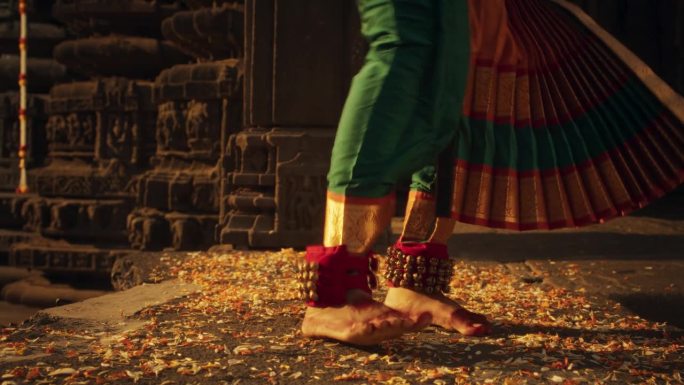 一个印度女舞者的腿做民俗舞蹈的特写镜头。穿着传统纱丽的女孩的地面镜头迅速展示了巴拉塔纳塔姆舞蹈的艺术