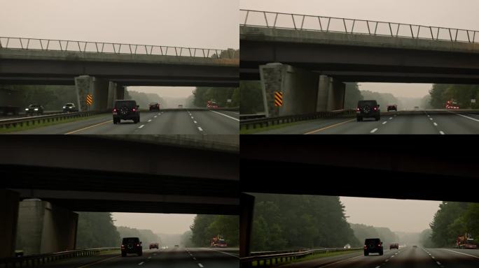 在桥下行驶:汽车在通往马里兰州的烟雾弥漫的道路上，从人行道下面经过。驾驶板摄影机运动