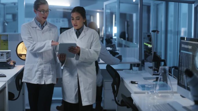 妇女，科学家和平板电脑在实验室讨论的实验，研究和测试的DNA。女博士，通过基因科学的分析、数据和筛选