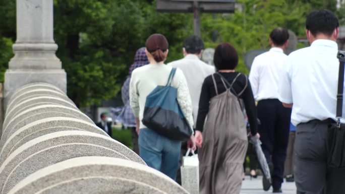 日本，大阪:一群人走在商业区的背影。