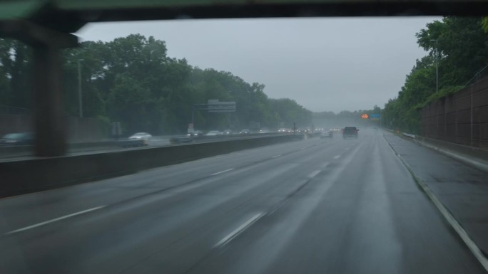 驾车穿越风暴:在暴雨中行驶在被洪水淹没的高速公路上的汽车，弗吉尼亚州。驾驶牌照，POV汽车司机