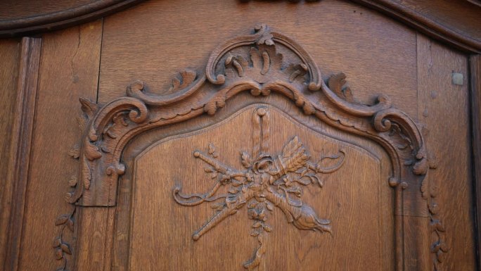 传统的门艺——在老木纹上进行细致的花朵装饰。手工制作的复杂花卉。古代木门装饰