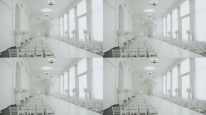 婚礼大厅装饰成白色，准备迎接宾客。美丽的房间为仪式和婚礼在白色的颜色，白色的椅子和白色的花卉组成。婚