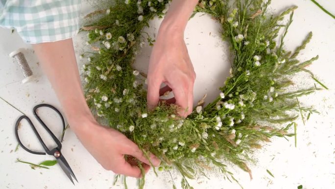 为伊万·库帕拉的盛宴编织花圈的花艺大师班。妇女用新鲜的草药和鲜花编织花环，这是异教徒的象征，冬至日。
