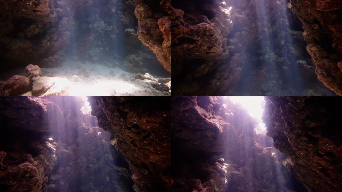 阳光透过岩石的裂缝照射到红海的水下洞穴中，创造出令人惊叹的色彩游戏