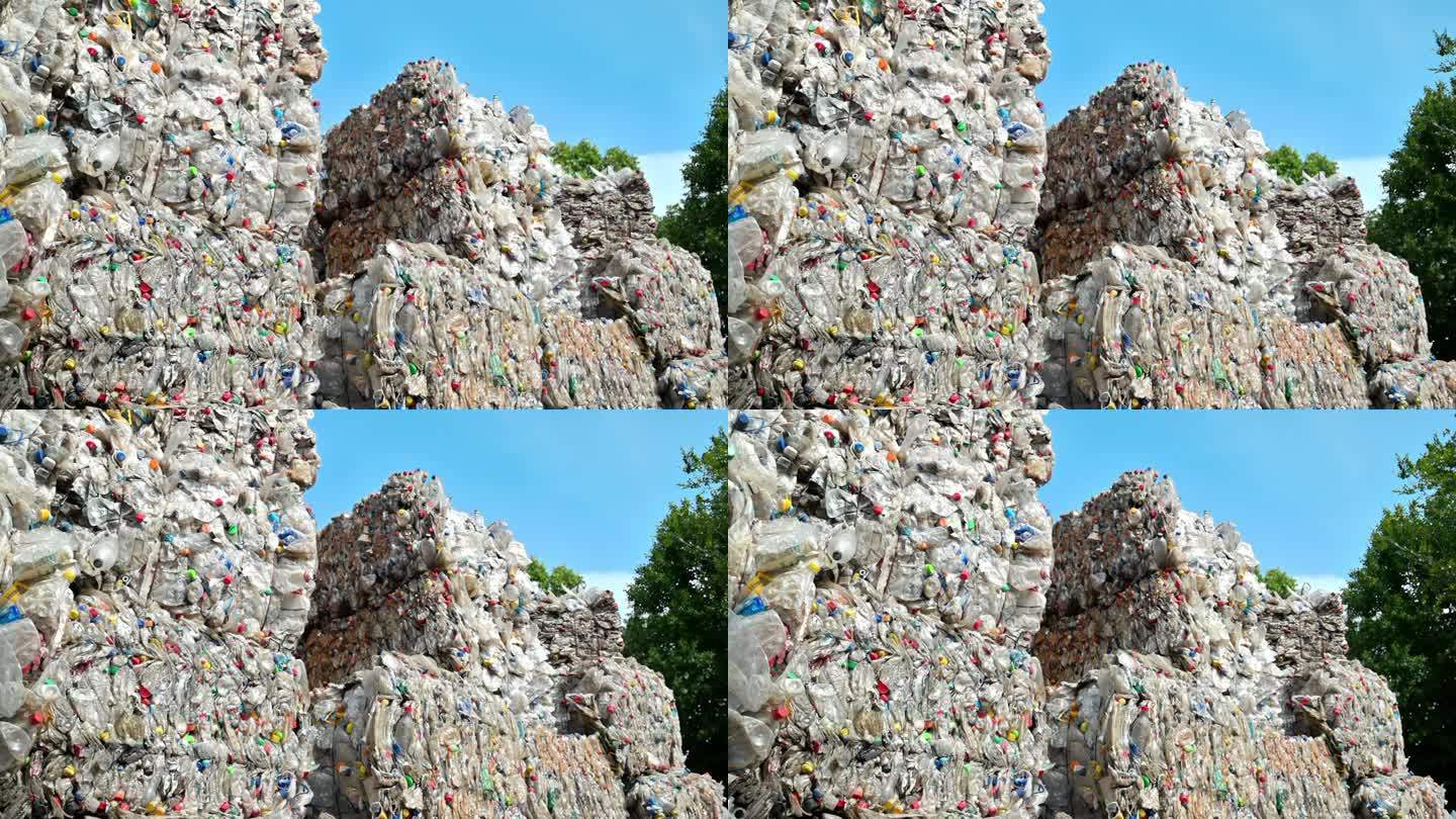 多堆压缩透明塑料垃圾在露天废物回收厂。慢动作