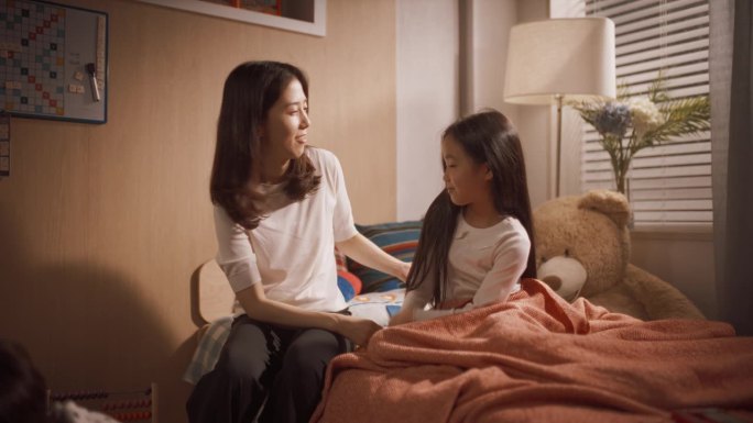 美丽的韩国母亲走进孩子们的房间。小儿子在玩玩具，女儿醒了，可爱地伸伸胳膊。可爱的亚洲家庭准备一起度过