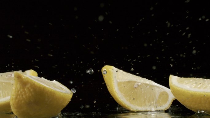 柠檬在黑背景上落下散开水花飞溅慢镜头合集