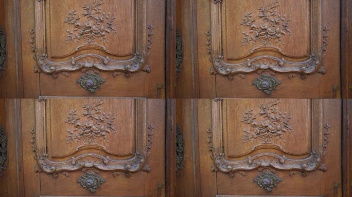 传统古木门上的纹饰细节。花卉装饰错综复杂，材质手工