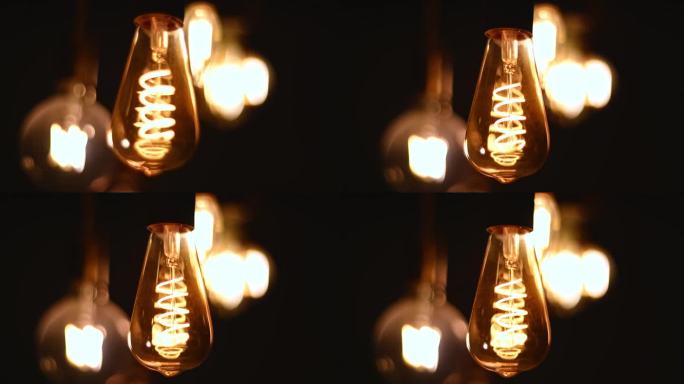 螺旋复古灯泡挂在黑暗的背景。电,古董