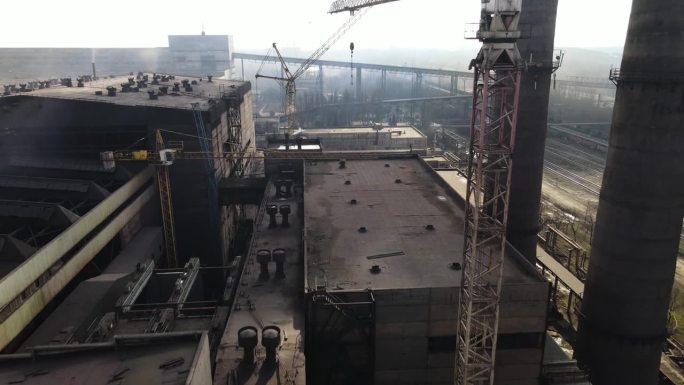 无人机拍摄的钢铁厂管道航拍画面。在冶金厂的上空，一团烟雾正从烟囱里冒出来。
