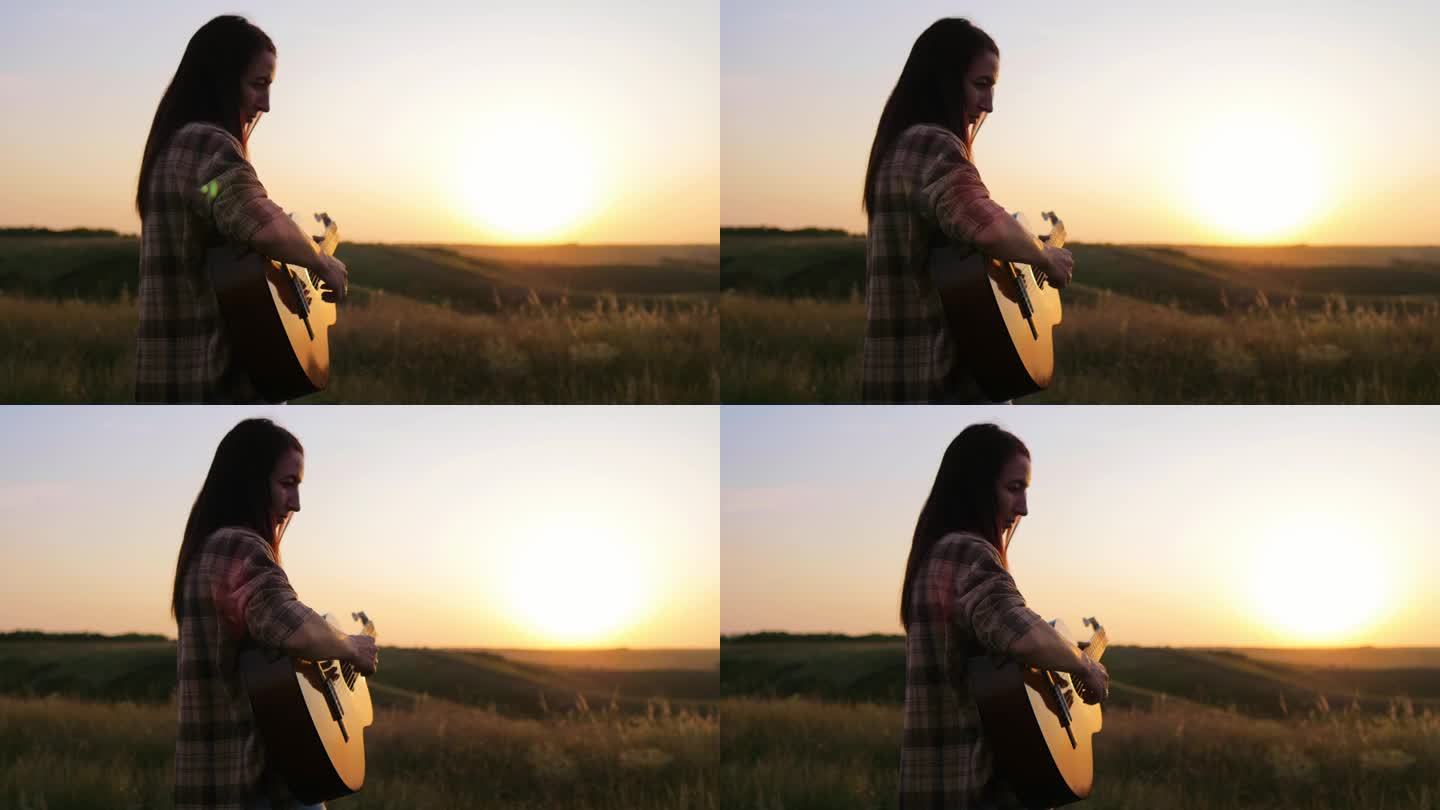 弹吉他。美丽的年轻女子弹吉他在天空日落。夕阳下手持吉他的女音乐家剪影。