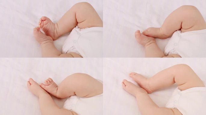 在一张白色的隔离照片中，一个新生婴儿的腿躺在床上，婴儿的脚跟特写在焦点上