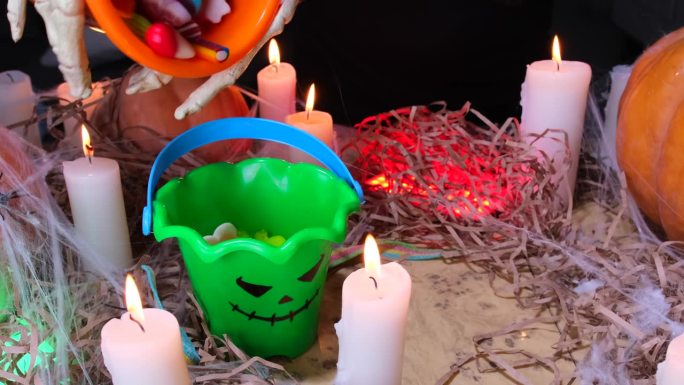 糖果上的快乐万圣节和秋天的装饰庆祝夜晚的精神，骷髅倒了很多五颜六色的糖果从桶到桶，