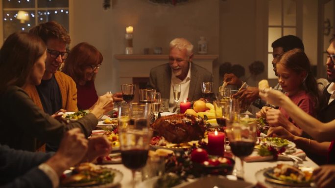 多元文化的亲密朋友和家人一起享受圣诞火鸡晚餐，一起度过节日。节日晚上的气氛，圣诞装饰在家里