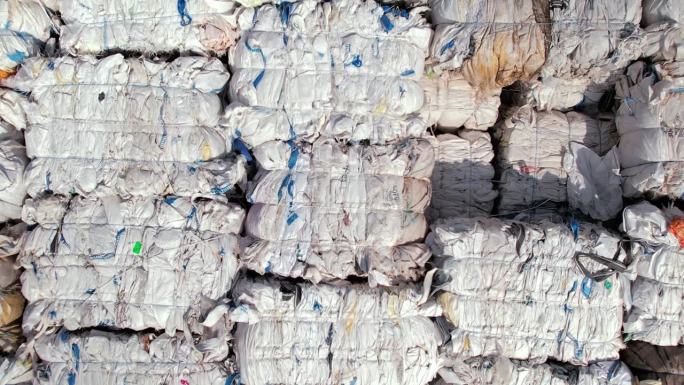 多个立方体的压缩织物垃圾在废物回收工厂在露天
