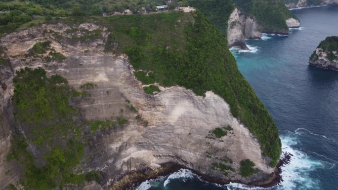 Pura Paluang神庙位于Nusa Penida高陡的岩壁边缘，上面覆盖着郁郁葱葱的绿色植被。