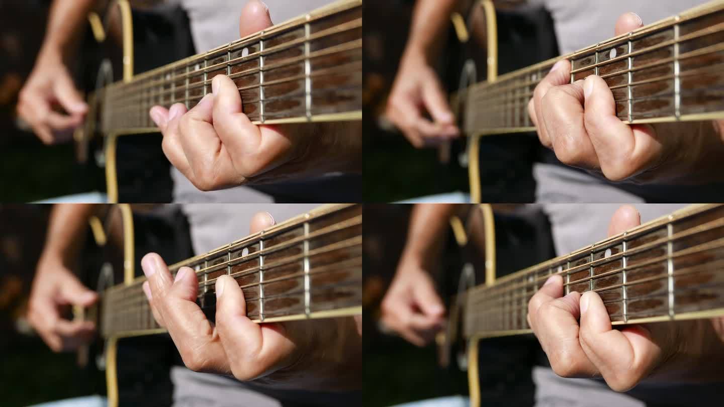 吉他弦乐器:户外弹吉他的人。吉他脖子，特写镜头。弹原声吉他和弦的人。音符。音乐家在阳光下弹奏吉他。在