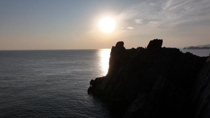 航拍威海市环翠区猫头山海岛礁石日出看海人