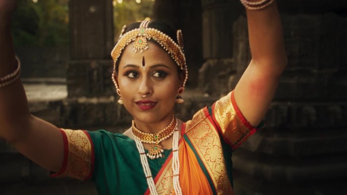 一个充满活力的印度妇女的慢动作肖像，穿着传统服装，脸上表情丰富，动作迅速，跳着巴拉塔纳塔扬舞。古庙中