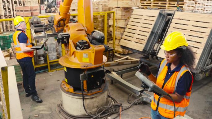机器人工程师检查和修理自动机械臂的工作，检查情况是否完美，可以在工厂使用
