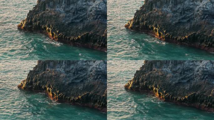 当海浪撞击岩石时，黄金时刻的光芒洒在被侵蚀的特内里费岛的海上悬崖上