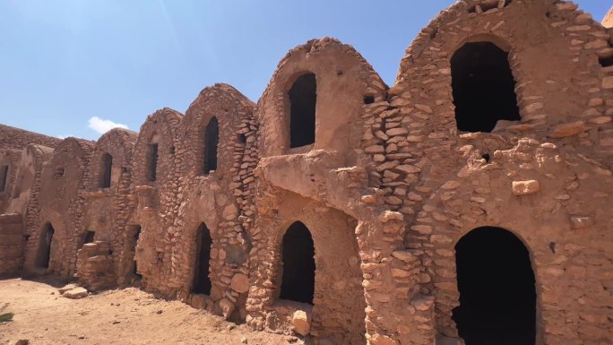 在突尼斯，Ksar Hadada粮仓废墟与清真寺为背景。平移
