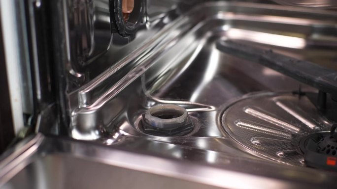不认识的人特写:打开盖子，将漏斗插入洗碗机孔中，将颗粒盐倒入洗碗机孔中，软化硬水。
