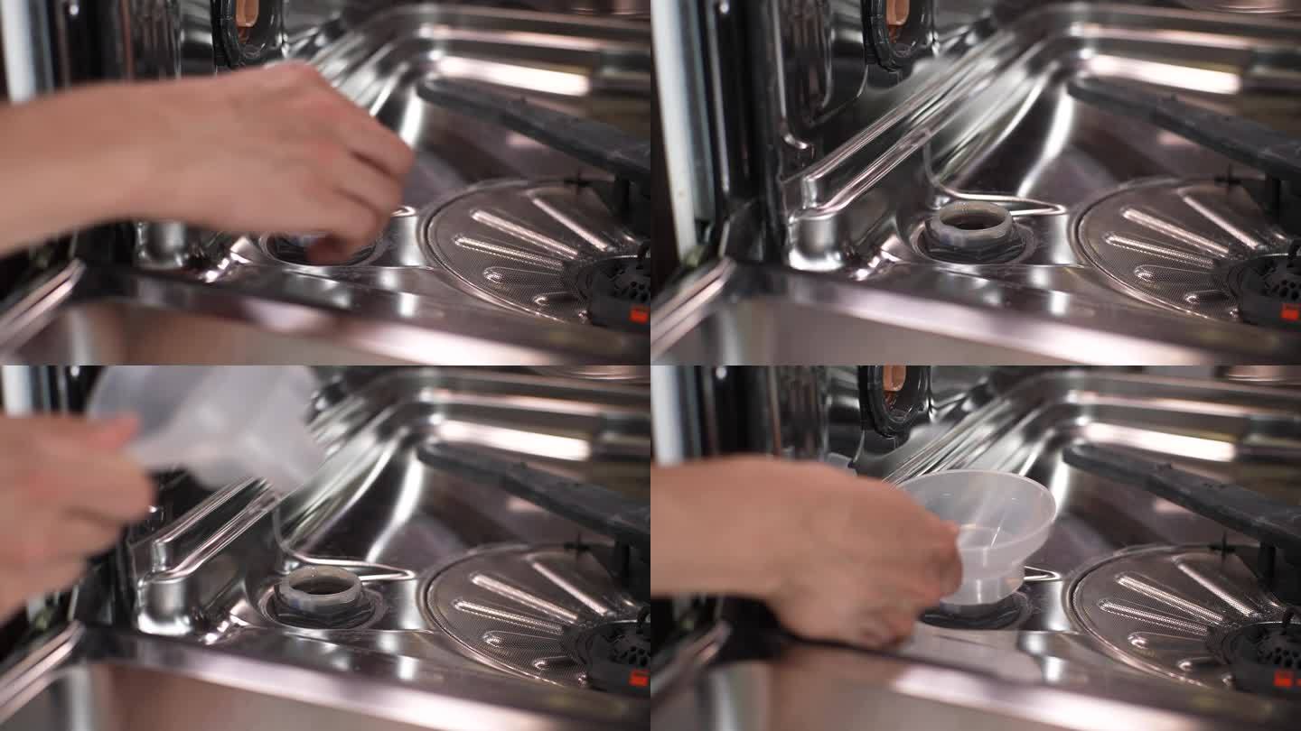 不认识的人特写:打开盖子，将漏斗插入洗碗机孔中，将颗粒盐倒入洗碗机孔中，软化硬水。