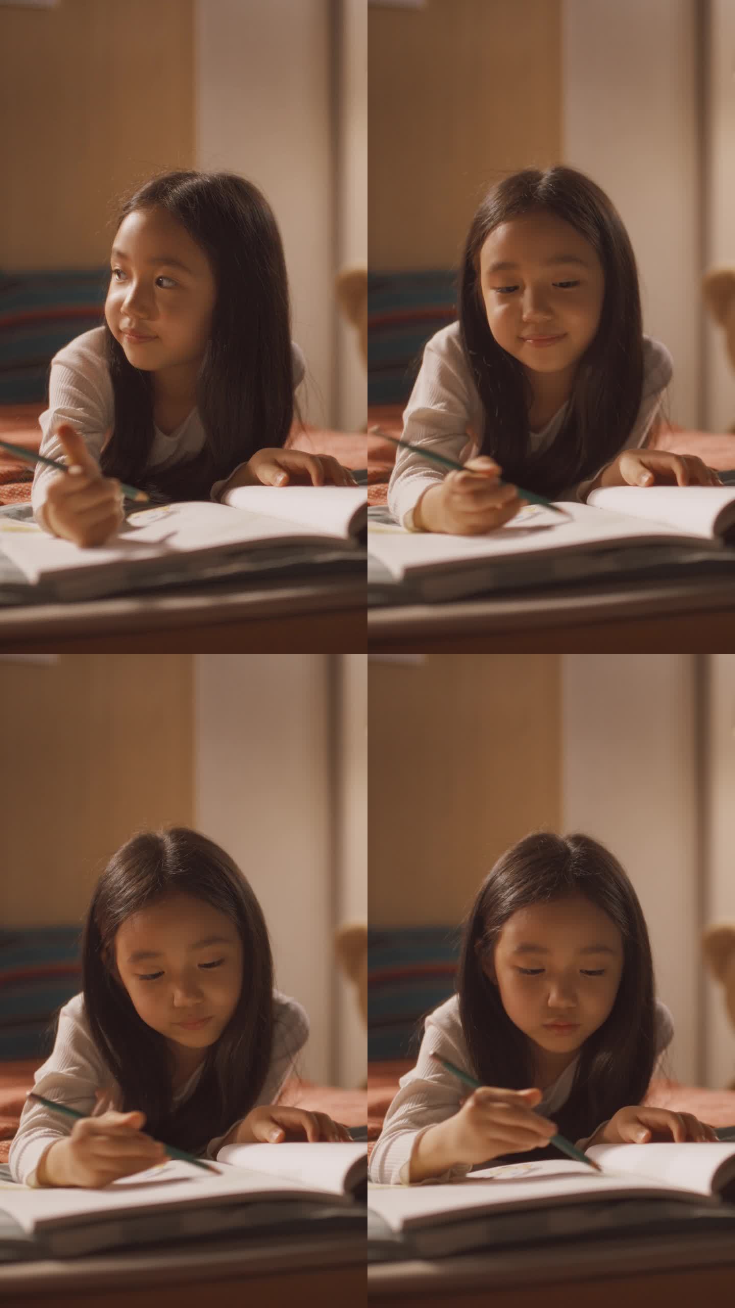 垂直屏幕:可爱的韩国小女孩躺在床上，用钢笔和铅笔在笔记本上画画。快乐和创造性的女孩子在家里在她的房间