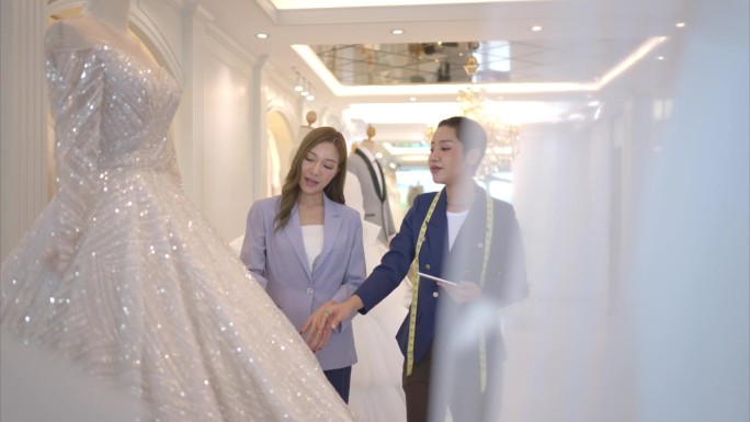 两位亚洲时装设计师都在婚纱店设计婚纱