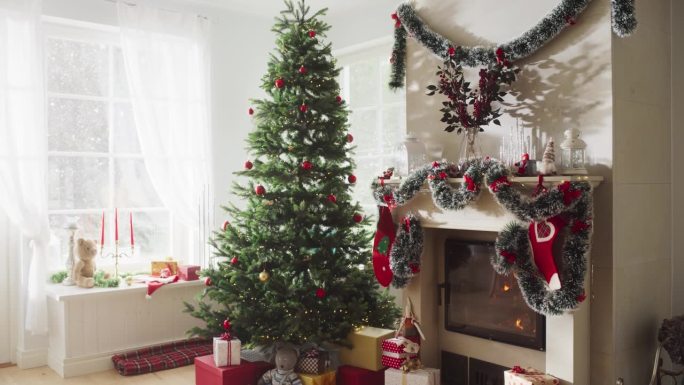 在一个和平的下雪的圣诞节早晨，空镜头描绘了节日的魔力:装饰在现代房子的角落里，有圣诞树，壁炉和礼物。