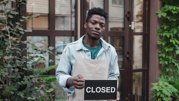 非裔美国咖啡馆工作人员举着写有“关闭”字样的牌子
