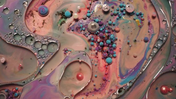 彩虹泡泡的油漆和墨水在水中。五颜六色的液体不停地旋转和混合