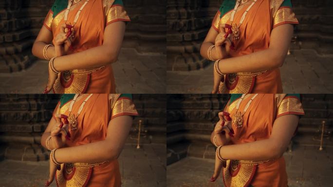 近距离慢镜头拍摄印度女舞者的手做象征性的手势，在民俗舞蹈中传达不同的信息。穿着传统纱丽的女孩展示手印
