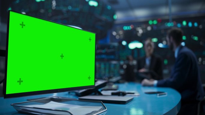 证券交易所。绿屏模拟电脑显示焦点。两个交易员在后台工作，讨论金融和商业机会，市场研究和投资