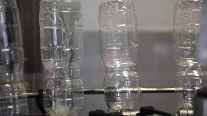 自动机器清洗空塑料瓶颠倒在醋厂与特写镜头。