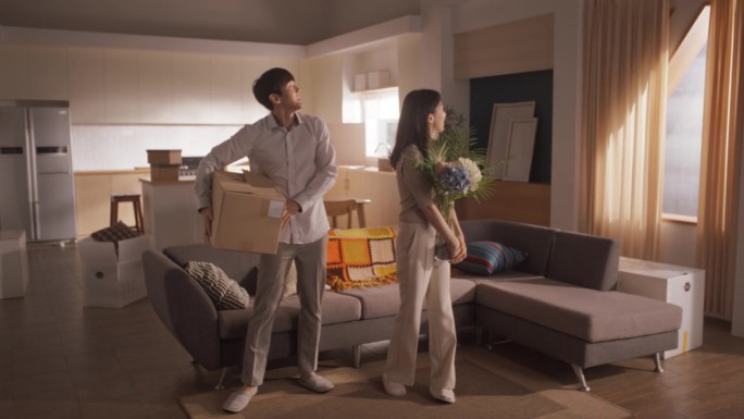 家庭搬家:幸福和兴奋的年轻韩国夫妇进入新购买的公寓。幸福拥抱的美丽家庭。准备好装饰的现代家居。按揭贷