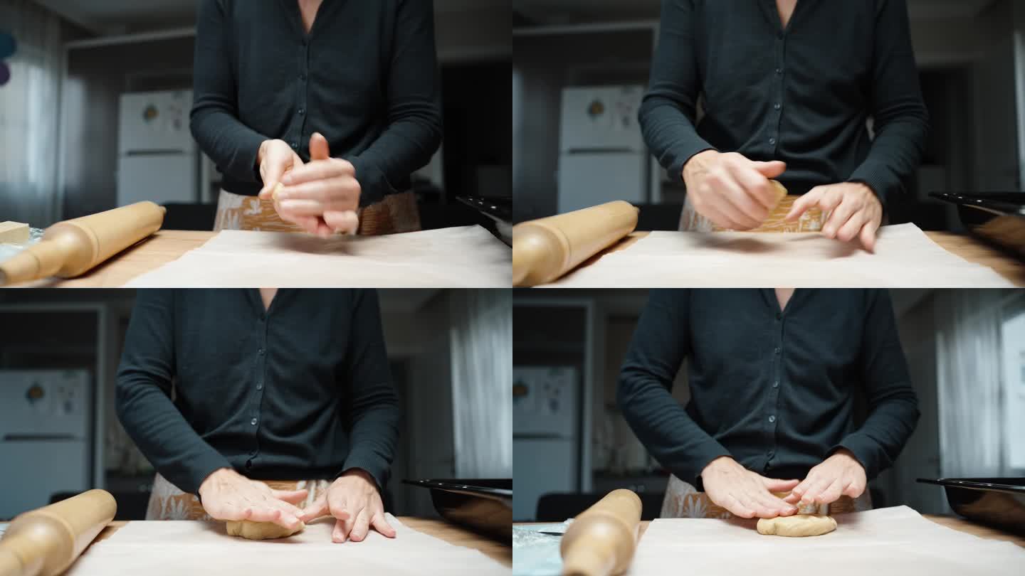女人用手在烤纸上擀出姜饼面团，准备烘烤。