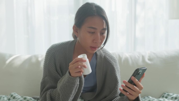 近距离的亚洲年轻女孩患者通过手机视频通话咨询医生药物剂量说明在医疗app上在家远程医疗在线服务。居家