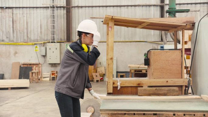 卡彭特使用大型工业机械。用于抛光木材表面和切割木材成块储存和出口
