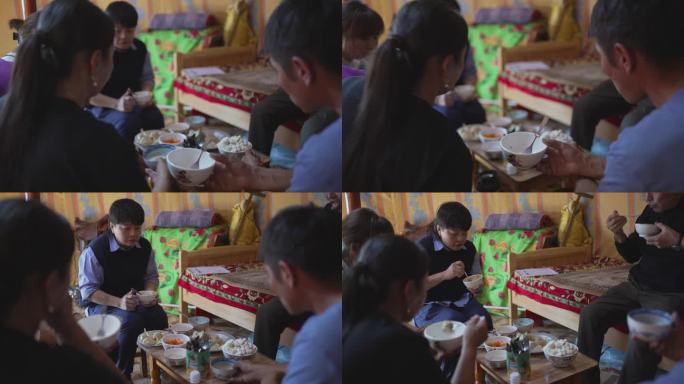 亚洲中国女游客在蒙古包里与当地游牧家庭一起享用蒙古传统美食