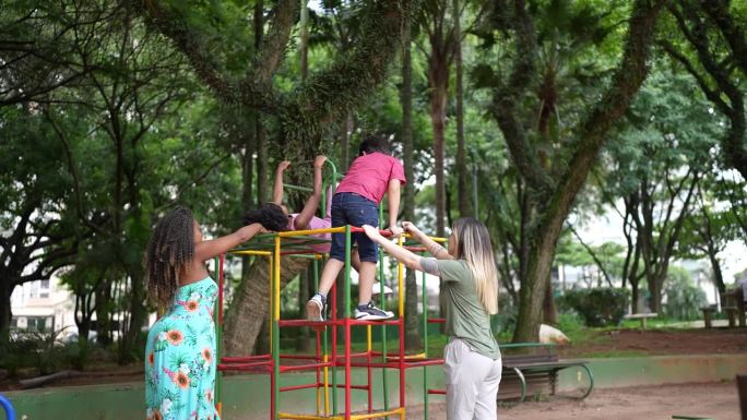 孩子们在攀爬架上玩耍，而他们的妈妈在公园帮忙