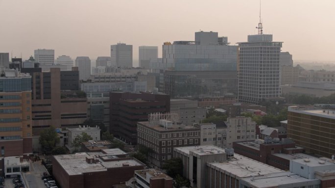 里士满商业区和城市道路被大火烟雾笼罩。杰克逊沃德和范区在里士满，弗吉尼亚州。航拍镜头下降和平移相机运