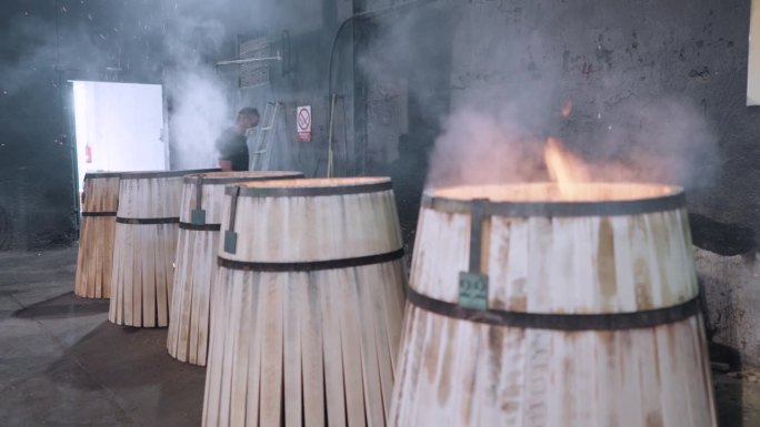 视频4K Prores HQ。工人在赫雷斯(雪利酒)的一个合作社添加一块剩余的橡木逐渐烤桶的内部