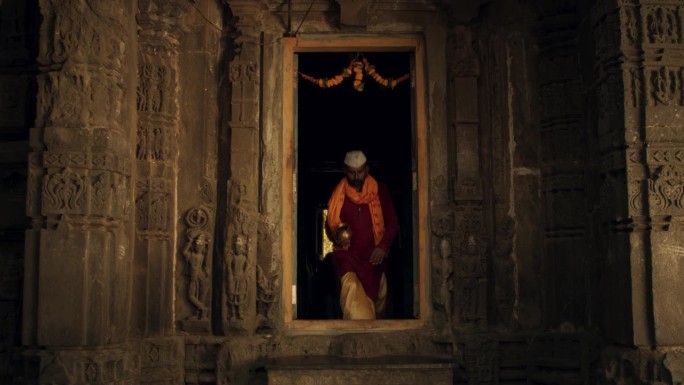 一个印度人走进一座古庙的真实镜头。虔诚的男信徒走进他的礼拜场所，寻求指导和智慧，为宗教仪式做好准备